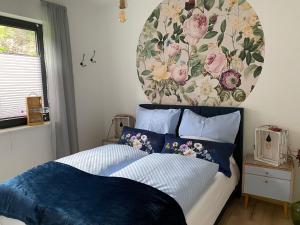 1 dormitorio con 1 cama con una pintura floral en la pared en Schmidtsches Quartier en Hain