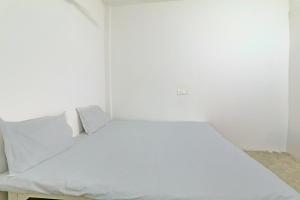 a small bedroom with a white bed in it at OYO Arnav Guest House in Gorakhpur