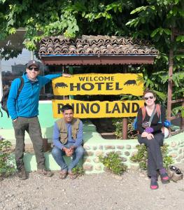 a group of people sitting in front of a welcome sign at Hotel Rhino Land, Sauraha in Sauraha