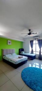een slaapkamer met 2 bedden en een groene muur bij De Viana Apartments Homestay in Kota Bharu