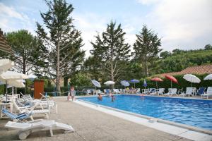 a swimming pool with chairs and umbrellas at Agriturismo VILLA MOZART nel verde in Gubbio