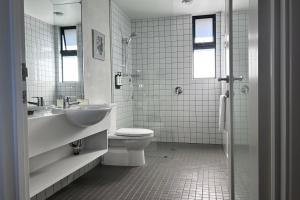 a bathroom with a toilet and a sink and a shower at Edge of the Bay Resort in Coles Bay