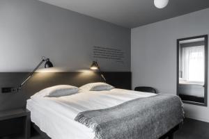 a bedroom with a large white bed and a window at Skuggi Hotel by Keahotels in Reykjavík