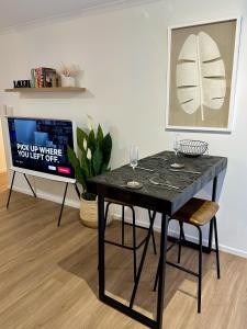 un tavolo nero con bicchieri da vino sopra in una stanza di Luxe Palm Studio Villa - In the heart of Edge Hill a Edge Hill