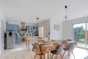 uma cozinha com mesa e cadeiras e uma cozinha com armários azuis em Splendid family home in Toulouse em Toulouse