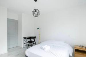 um quarto branco com uma cama e uma mesa em Splendid family home in Toulouse em Toulouse