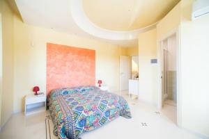 um quarto com uma cama com uma colcha colorida em Relais il Melograno em Arnesano
