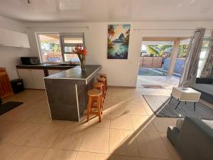 uma cozinha com um balcão e bancos num quarto em Maison Te Manu - plage privée avec vue sur Tahiti à quelques pas em Maatea