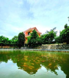 una casa en la cima de un lago con un edificio en Khách sạn Phương Thuý 2, en Yen Bai