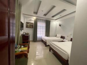 a hotel room with two beds and a window at Khách sạn Phương Thuý 2 in Yen Bai