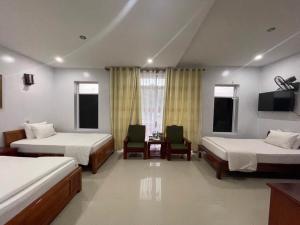 um quarto de hotel com duas camas e uma televisão em Khách sạn Phương Thuý 2 em Yen Bai