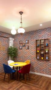 une salle à manger avec une table jaune et des chaises colorées dans l'établissement Close, à Islamabad