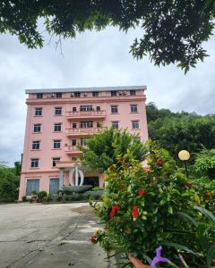 różowy budynek z kwiatami przed nim w obiekcie Khách sạn Phương Thuý 2 w mieście Yen Bai