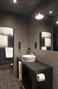 a bathroom with a sink and a mirror and towels at Skuggi Hotel by Keahotels in Reykjavík