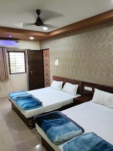 1 dormitorio con 2 camas y techo en Green leaf Hotel en Ujjain