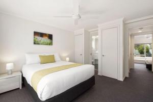 a white bedroom with a large bed and a window at Island Breeze Resort in Cowes