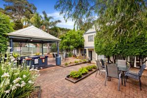 a patio with a table and chairs and a grill at Island Breeze Resort in Cowes