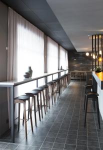 a row of stools at a bar in a restaurant at Skuggi Hotel by Keahotels in Reykjavík