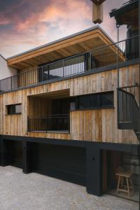- un bâtiment en bois avec un balcon au-dessus dans l'établissement Astei Suites, à Grossarl