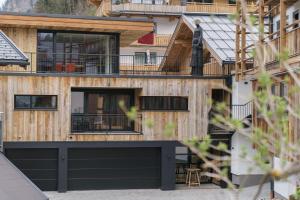 une maison en bois avec un garage noir dans l'établissement Astei Suites, à Grossarl