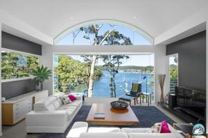 a living room with a large window with a view of the water at Aircabin - Daleys Point - Waterfront Retreat House in Daleys Point