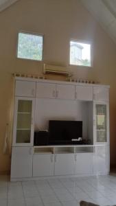 - une cuisine avec des placards blancs et 2 fenêtres dans l'établissement Villa Eindhoven R9 / 3 Kota Bunga Cipanas Bogor, à Cimacan