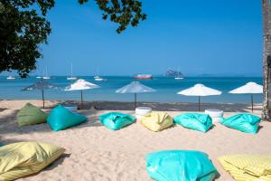 Royal Yao Yai Island Beach Resort في كو ياو ياي: مجموعة من الوسائد على الرمال على الشاطئ