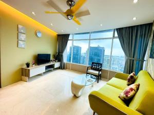 a living room with a yellow couch and a large window at Soho Star Suites near by Klcc in Kuala Lumpur