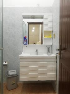 uma casa de banho com um lavatório branco e um espelho. em Sultan Guest House Lahore em Lahore