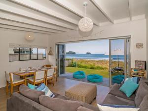 a living room with a view of the ocean at Beachfront Beauty - Whangamata Beachfront Home in Whangamata