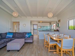 a living room with a table and a couch at Beachfront Beauty - Whangamata Beachfront Home in Whangamata