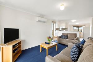 a living room with a couch and a flat screen tv at Marine Cove Resort in Goolwa South