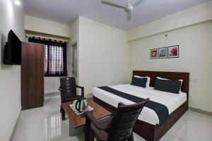 - une chambre avec un lit, un bureau et une télévision dans l'établissement OYO KPC Comfort, à Bangalore