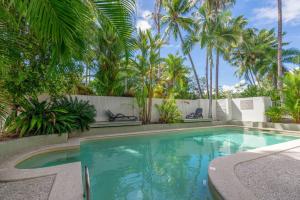 - une piscine dans une cour avec des palmiers dans l'établissement Tropical Escape, à Port Douglas