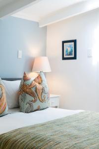 a bedroom with a bed with a pillow and a lamp at Willets Boutique Hotel in the heart of Simon's Town in Simonʼs Town