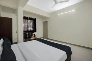 - une chambre avec un lit blanc et un ventilateur de plafond dans l'établissement OYO KPC Comfort, à Bangalore
