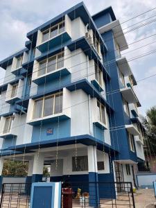 Sai Homestay Panaji Studio في باناجي: مبنى بلو وبيض بسقالات حوله