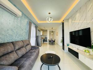 een woonkamer met een bank en een flatscreen-tv bij JB Country Garden J Agape Homestay 2308-9A in Johor Bahru