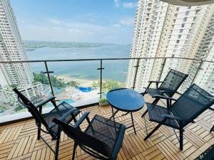 een balkon met stoelen en een tafel en uitzicht op de oceaan bij JB Country Garden J Agape Homestay 2308-9A in Johor Bahru