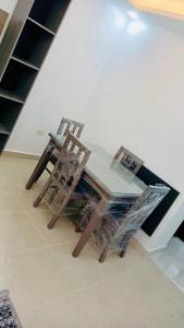 two chairs and a table in a room at شقة فندقية فاخرة - غرفتا نوم - تلاع العلي in Umm Uthainah