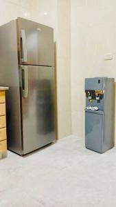 a stainless steel refrigerator in the corner of a kitchen at شقة فندقية فاخرة - غرفتا نوم - تلاع العلي in Umm Uthainah