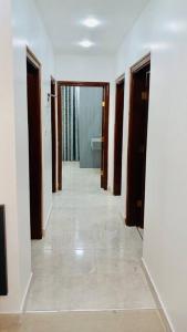 a hallway of a room with doors and a bathroom at شقة فندقية فاخرة - غرفتا نوم - تلاع العلي in Umm Uthainah