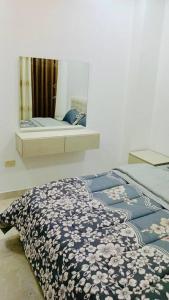 1 dormitorio con cama y espejo en la pared en شقة فندقية فاخرة - غرفتا نوم - تلاع العلي en Umm Uthainah