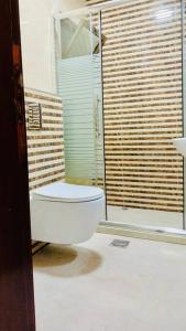 a bathroom with a toilet and a large window at شقة فندقية فاخرة - غرفتا نوم - تلاع العلي in Umm Uthainah