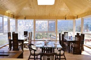 a dining room with tables and chairs and windows at MUSSOORIE ADVENTURE RESORT in Mussoorie