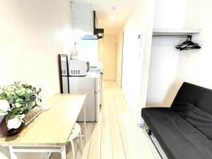 a small apartment with a table and a couch at Glanz Okubo 101 in Tokyo
