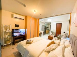 a bedroom with a large bed and a flat screen tv at Deluxe 1br - Uptown - Netflix, Pool #oursw15o in Manila