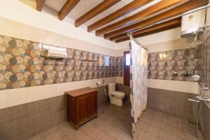 a bathroom with a shower and a toilet in it at Dumas Guest House in Puducherry