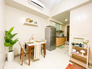 a kitchen with a table and a refrigerator at Deluxe 1br - Uptown - Netflix, Pool #oursw15o in Manila
