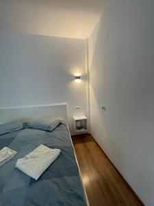 Cette petite chambre blanche comprend un lit et une lampe. dans l'établissement Arena Studio, à Piteşti